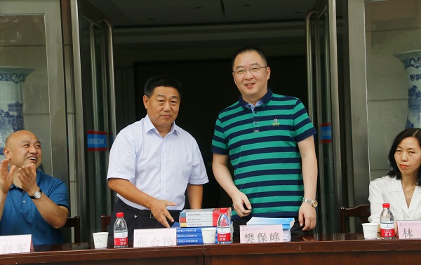 新乡市牧野区税务局党委书记、局长樊保峰向荣耀网页版登录入口_荣耀（中国）党委书记张会民赠送税法知识书籍.jpg